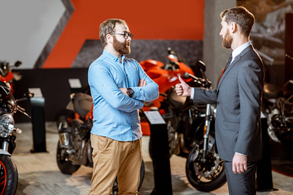 Dealer Training Source - Sales consultant with a client in the showroom with motorcycles